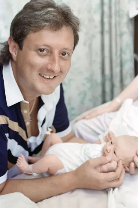 Framed Print : British darts player Eric Bristow poses at home with his new born baby girl who has been Framed Print : British darts player Eric Bristow poses at home with his new born baby girl who has been