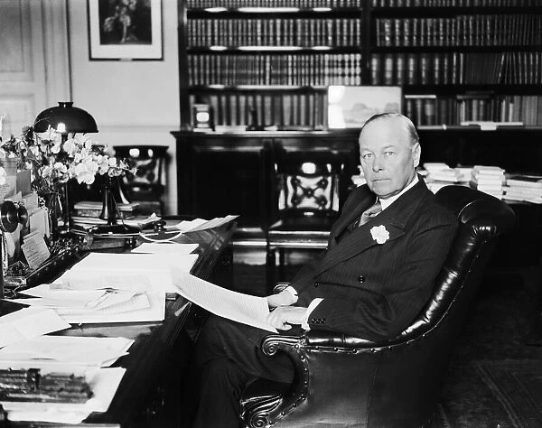 British Home Secretary Sir William Joynson-Hicks sitting at his desk in his office