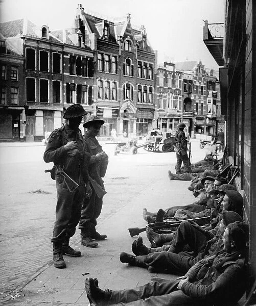 British Infantry soldiers take a rest in streets of Nijmegen after liberating the Dutch