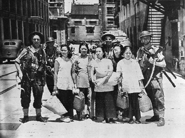 British Marines escort Chinese women from an occupied area in Hong Kong. 30th August 1945