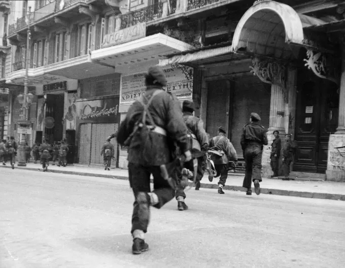 Framed Print : British paratroopers dash across a bullet swept street to storm a building in Athens