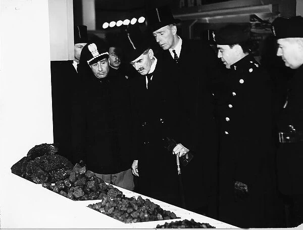 British Prime Minister Neville Chamberlain inspecting lumps of coal during a visit to