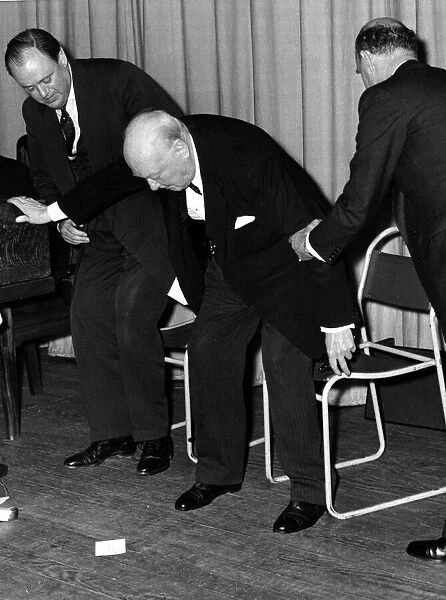 Former British Prime Minister and wartime leader Sir Winston Churchill is helped to his