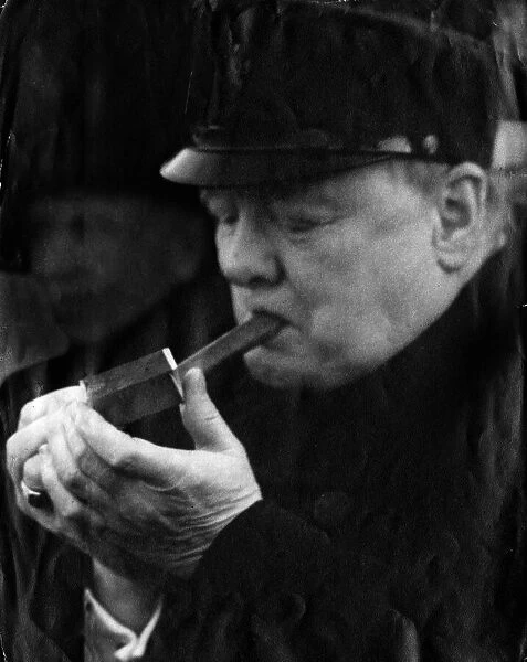 British Prime Minister Winston Churchill lights up one of his famous cigars