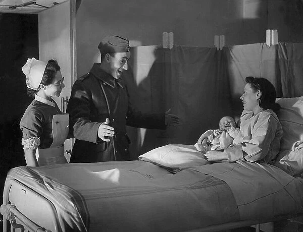 A British serviceman looks surprised as his wife presents him with a newborn baby
