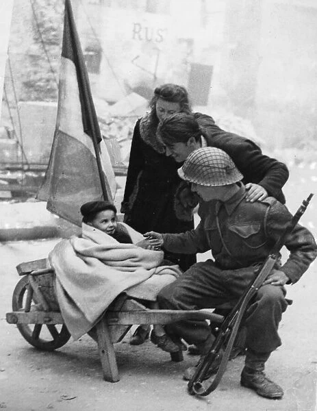 A British soldier of 3rd Division makes friends with a young French couple