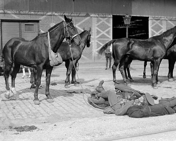 A British soldier takes a break while waiting for his horses to be loaded aboard a