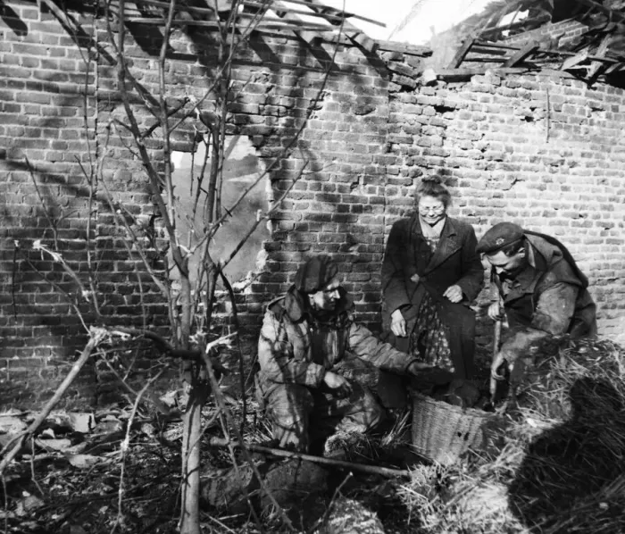 Framed Print : British soldiers gather fuel for an elderly Dutch woman outside the ruins of her home in