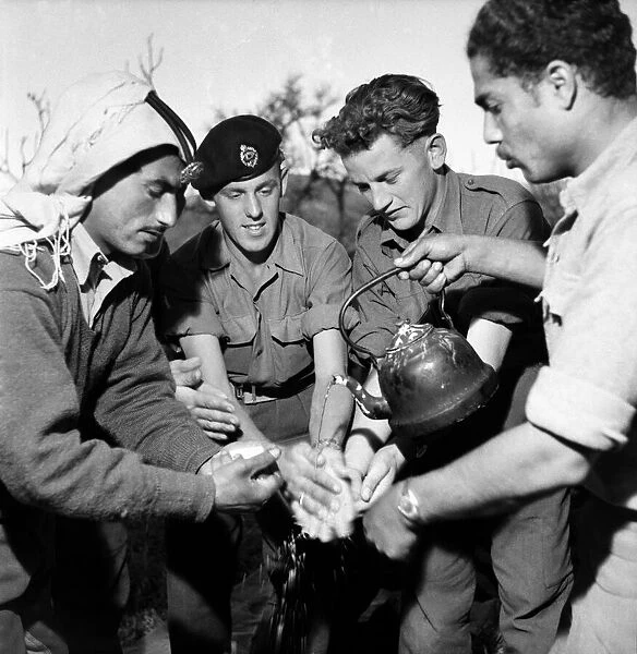 British soldiers and local Arab men enjoy a feast in Jordan. March 1952 C1287