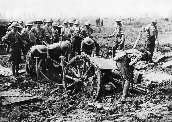 British soldiers man handle a gun bogged down in mud on the Western Front during