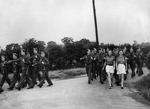 British Soldiers marching in the countryside, distracted by two young women they