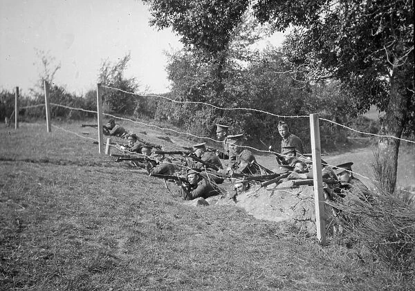 British soldiers waiting to fire on enemy from behind barbed wire