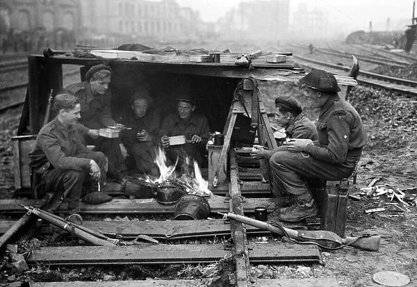British soldiers keep themselves warm and have some food during a break in fighting