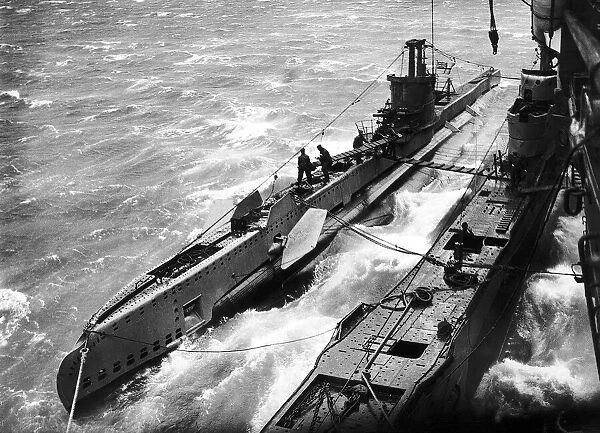 Two British submarines tied up to a supply ship prepare for another patrol during WW2