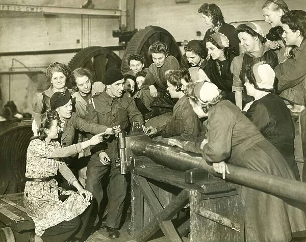 British trooper visits factory where the women make guns for his tanks A group of