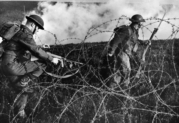 Framed Print : British troops advancing through barbed wire during a training drill. September 1943