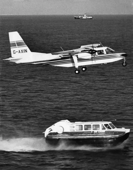 Framed Print : A Britten Norman Islander aircraft flies over a Cushion Craft Hovercraft