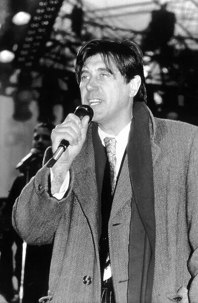 Bryan Ferry Singer with Pop Group Roxy Music singing on stage wearing overcoat and scarf