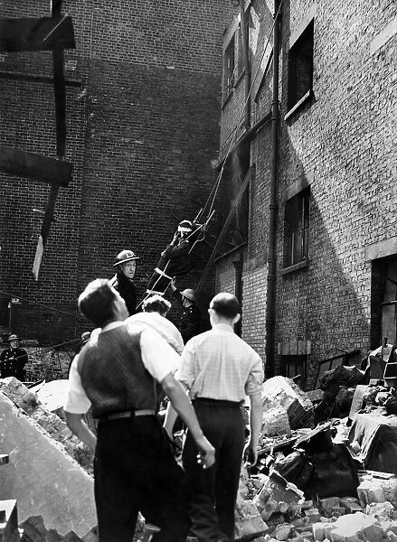 When a building was hit in a raid on this country firemen lowered an injured man from