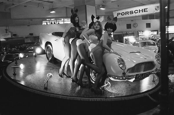 Bunny Girls drapped over an Aston Martin Volante car at the British International Motor
