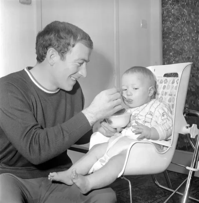 Framed Print : Burnley football player Ralph Coates feeds his new baby girl Lisa. December 1969 Z12543