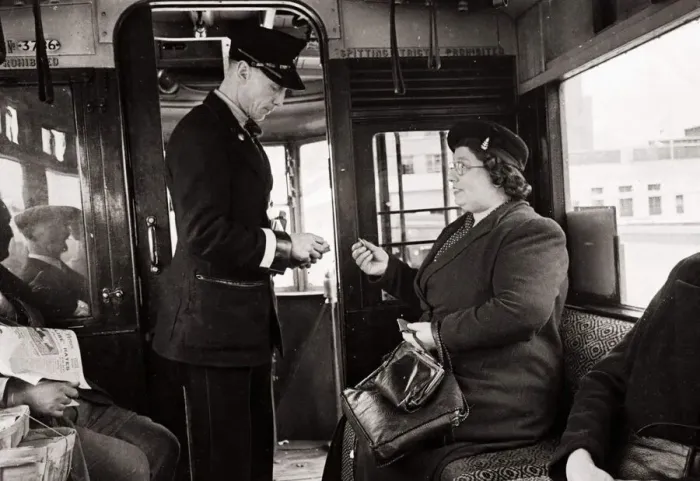 Framed Print : Bus Conductor collecting fares for passengers - circa 1948