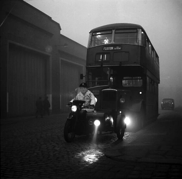 A bus being led by a motor cycle combination fitted with a special battary of lights at