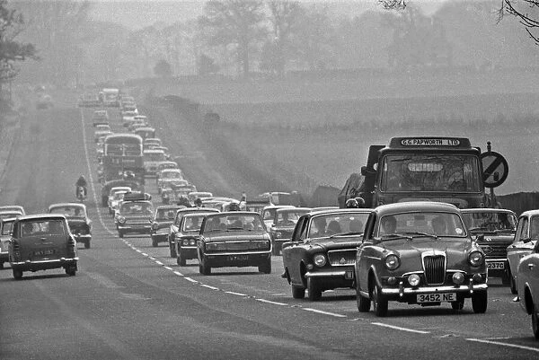 Buses and cars queue in built up traffic along the A556 towards Manchester