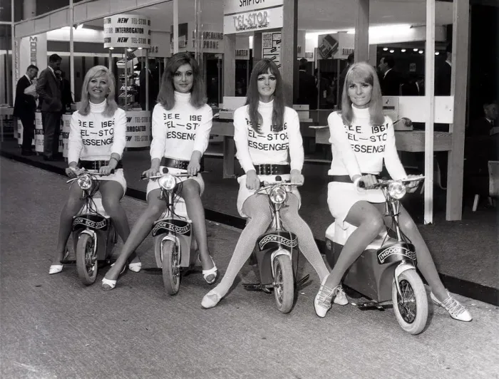 Framed Print : Business Efficiency Exhibition. Four mini-skirted messenger girls sit on their Electric Framed Print : Business Efficiency Exhibition. Four mini-skirted messenger girls sit on their Electric
