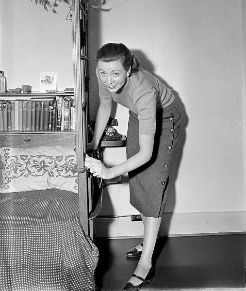 A busy housewife polishing the furniture at home Circa 1954