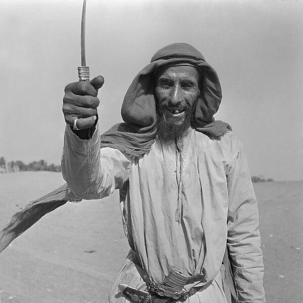 A camel herder seen here showing off his dagger, in Abu Dhabi. July 1965 U6027