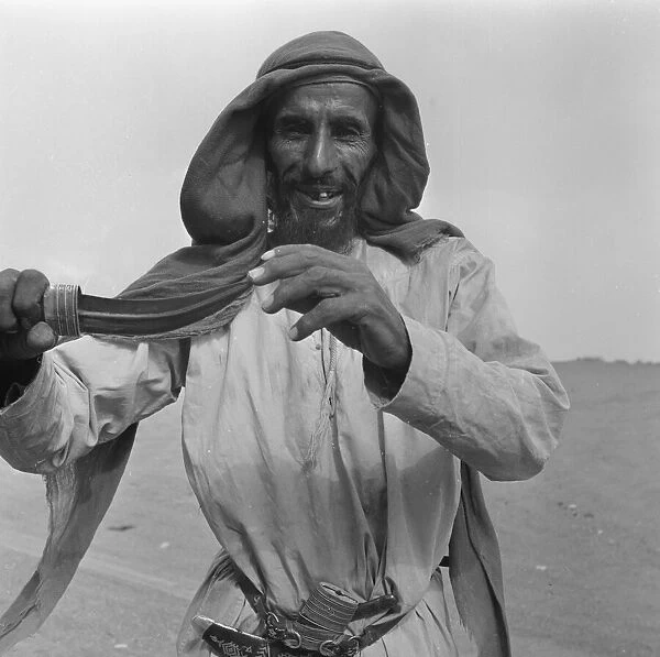 A camel herder seen here showing off his dagger, in Abu Dhabi. July 1965 U6027