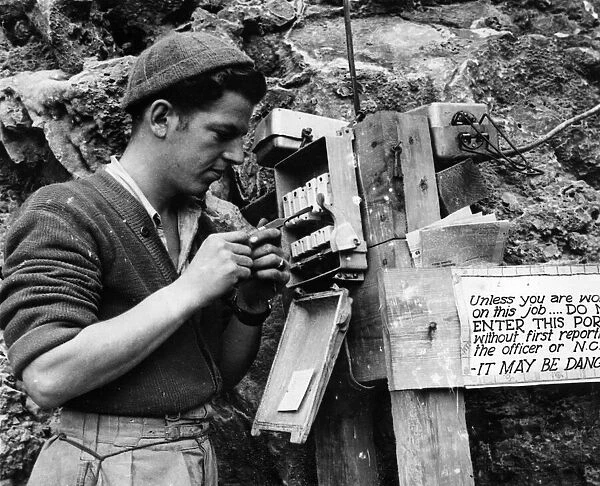 A Canadian Engineer repairs a fuse at the entrance to a tunnel in Gibraltar