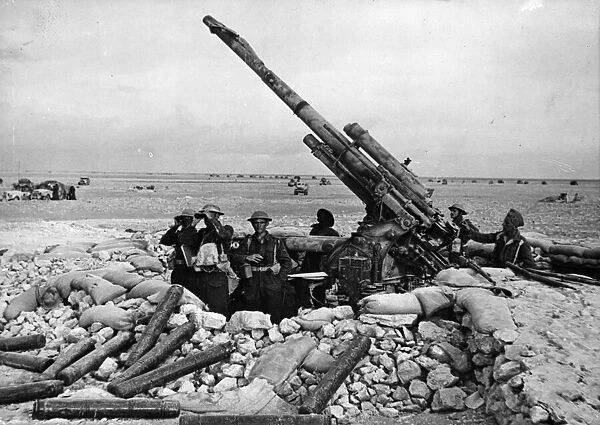 A captured Italian anti-aircraft gun, the pit of which is being used as an observation
