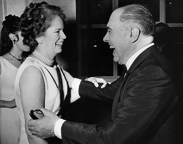 Carlo Ponti and Mrs Charlie Chaplin laughing together during a party at the Savoy Hotel