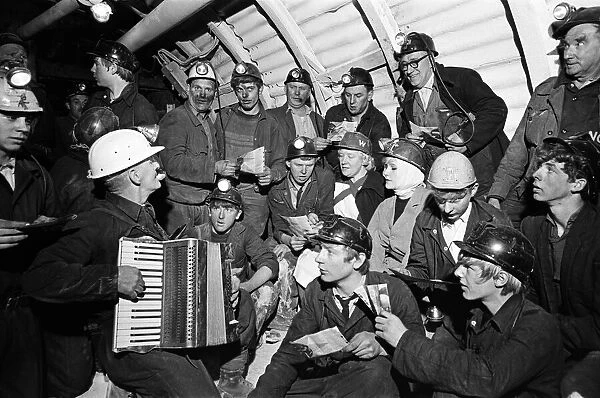 Carol service by miners 600 ft down. An accordion play and miners voices are raised in