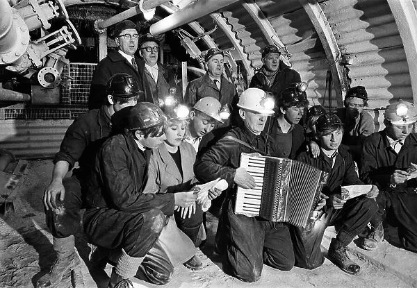 Carol service by miners 600 ft down. An accordion play and miners voices are raised in