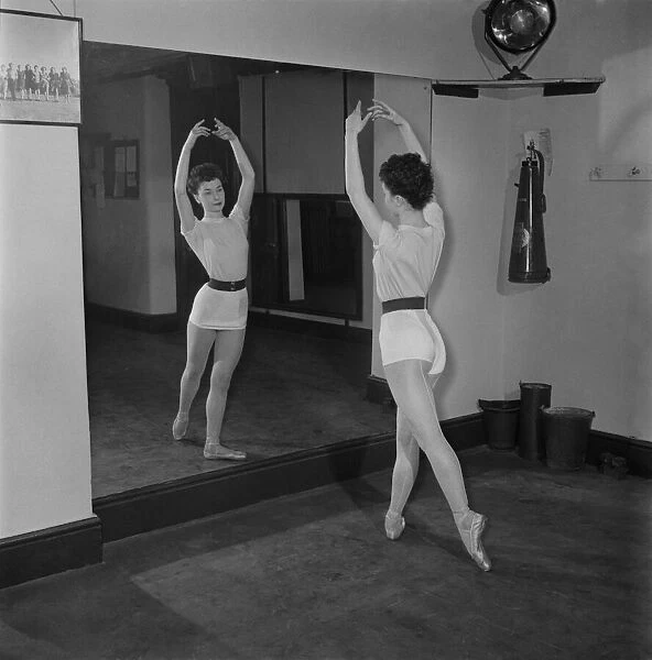 Carole Logan windmill girl doing stretches at the gym. November 1952 C5670-001