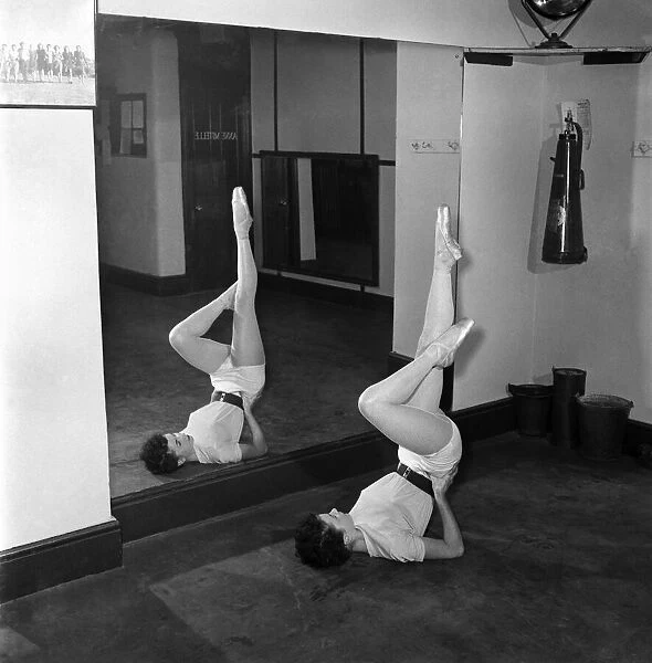 Carole Logan windmill girl doing stretches at the gym. November 1952 C5670