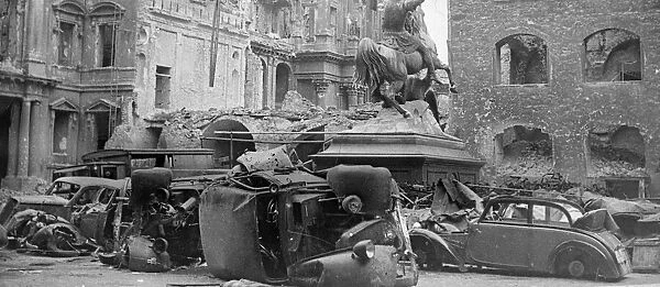 Cars lying in the road amongst the destruction caused by the Allied advance on Berlin