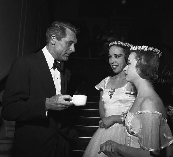 Cary Grant chats to two dancers between takes filming Indiscreet at the Royal Opera House