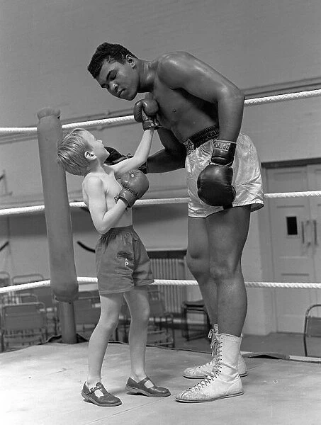 Cassius Clay with 6 year old Patrick Power in the ring during his training for