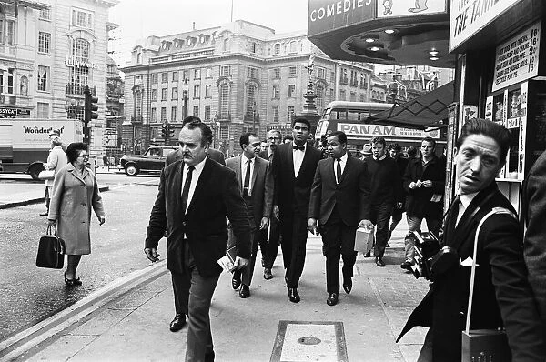 Cassius Clay (centre) and entourage walking down Charing Cross Road on route to his press