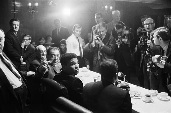 Cassius Clay (centre) at a press conference prior to his rematch with Henry Cooper to