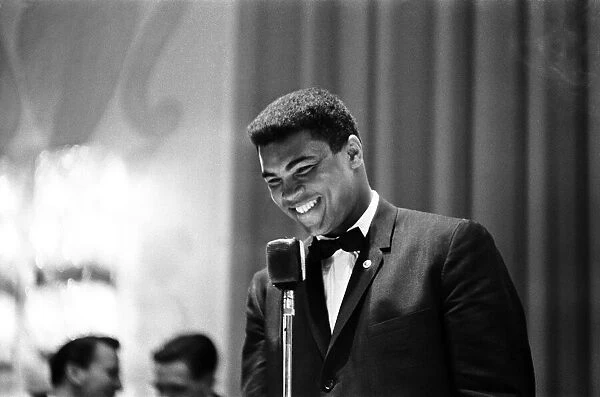 Cassius Clay (Muhammad Ali) laughing into microphone as he speaks at a sports writers