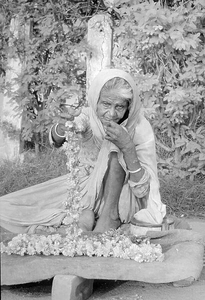 Cataracs dim the eyes of the old flower seller who sits at the enterance of Gandi