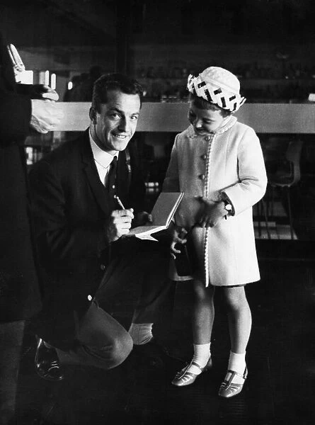 Celtic footballer Steve Chalmers signs an autograoh for a young fan at Abbotsinch Airport
