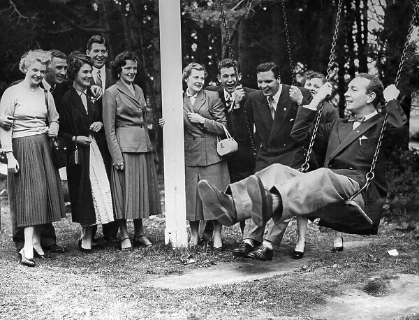 Celtic player Charlie Tully on a swing surrounded by team mates and their wives