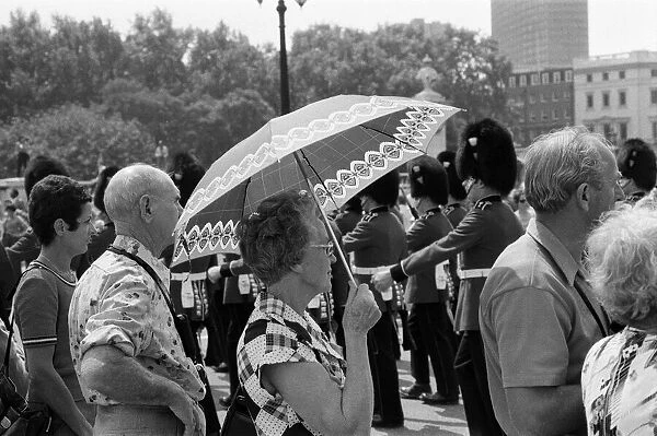 Changing of the Guard in London today. An umbrella serves as a sun-shade for a spectator