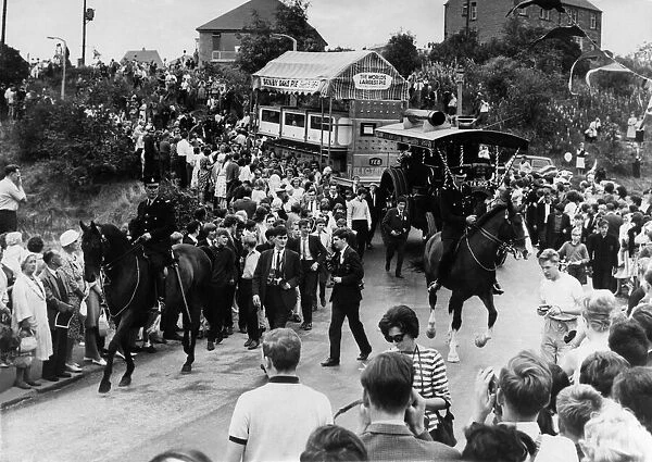 Cheering crowds greet the Denby Dale Pie, escorted by two mounted police